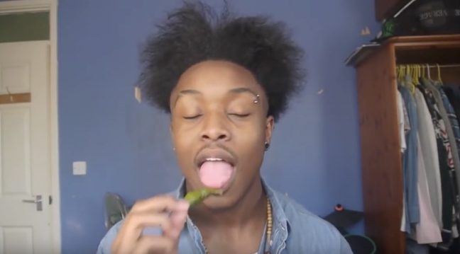 A Black man about to eat a naga chili