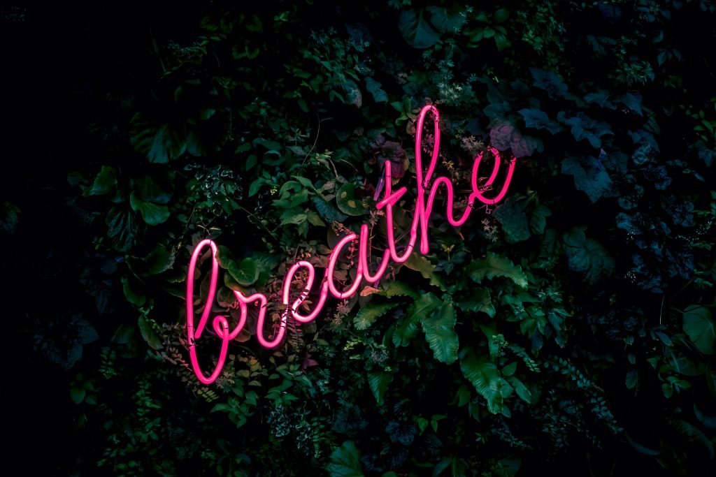 Pink neon sign that says "breathe"