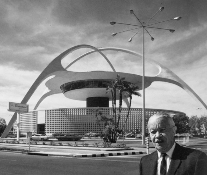 Paul R. Williams standing in front of the Theme Building in Los Angeles