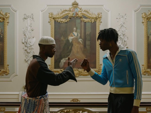 Two black people greeting each other in a museum.
